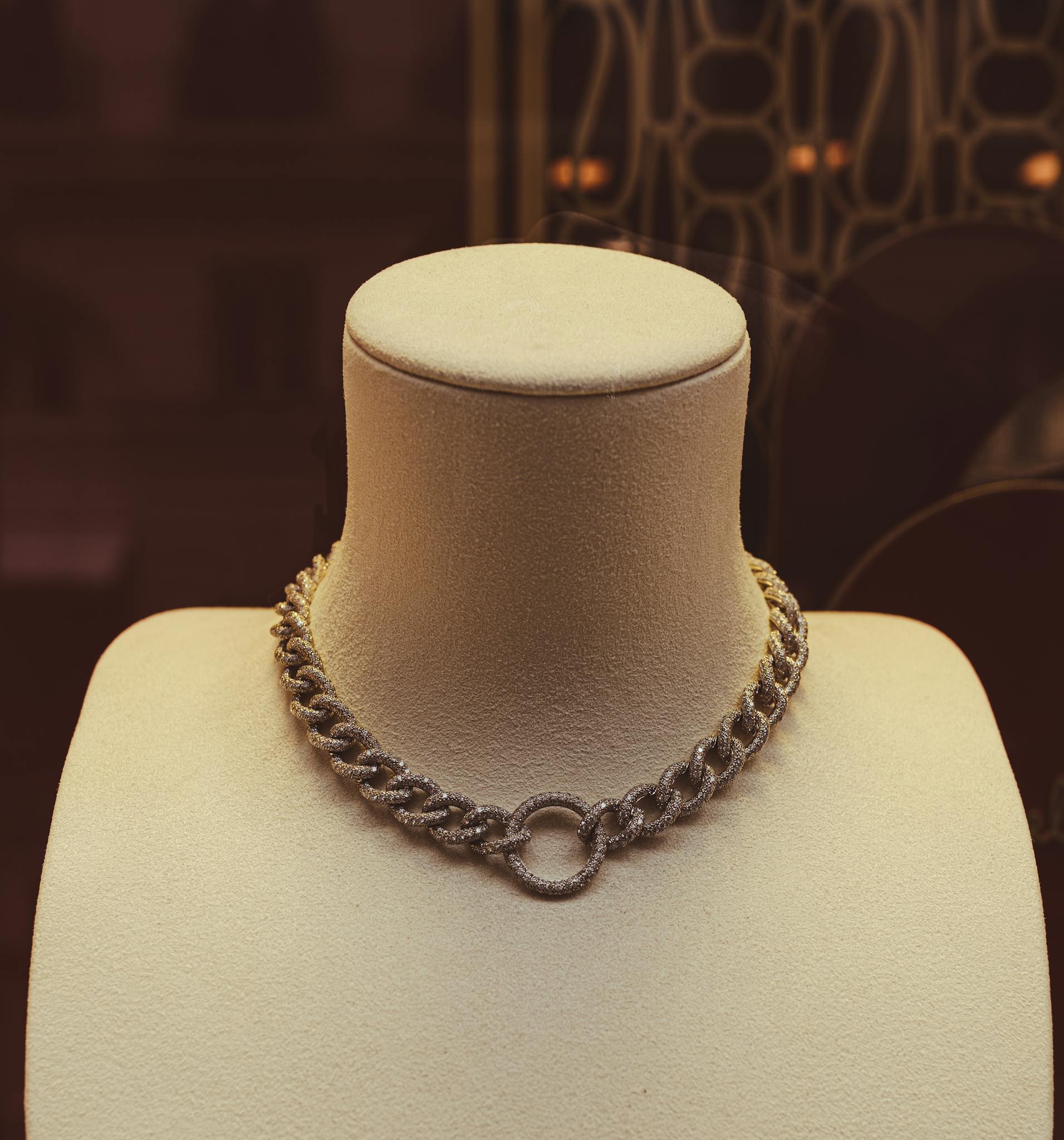 Chic necklace showcased on a mannequin in a luxurious store setting with artistic background.